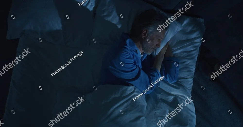 A woman lying awake in bed at night